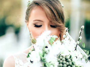 An image of a bride enjoying the scent of a wedding bouquet