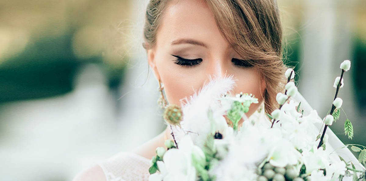 Image of a bride enjoying the scent of a wedding bouquet.