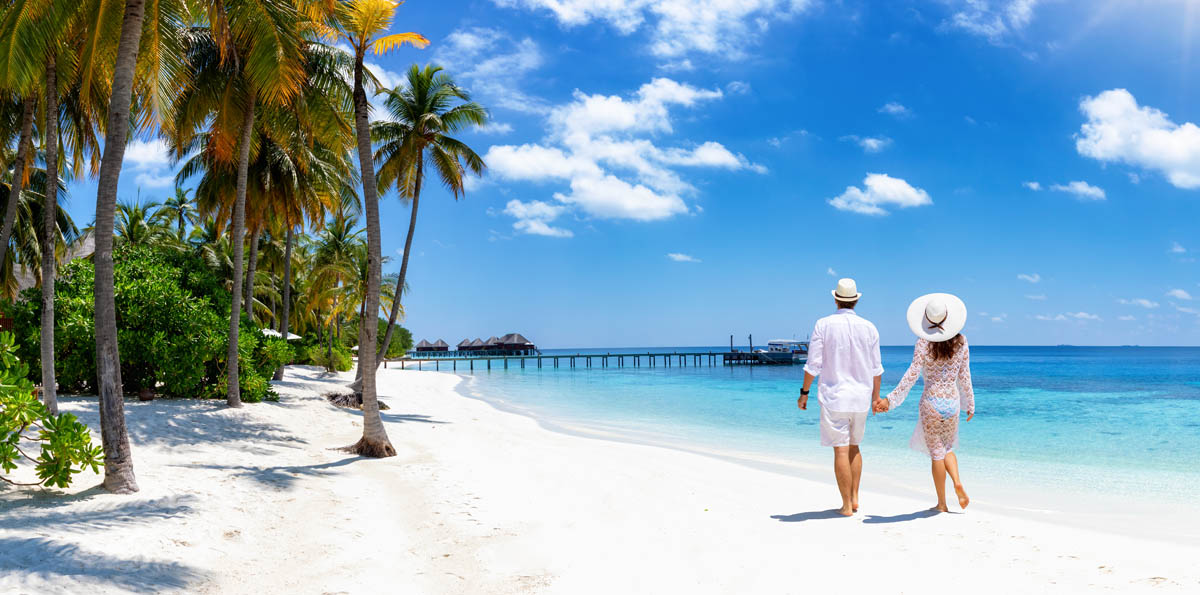 Image of a couple walking on a tropical beach.