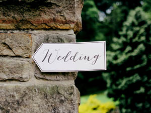 Image of a homemade sign on a wall with the word 'wedding' written on it.