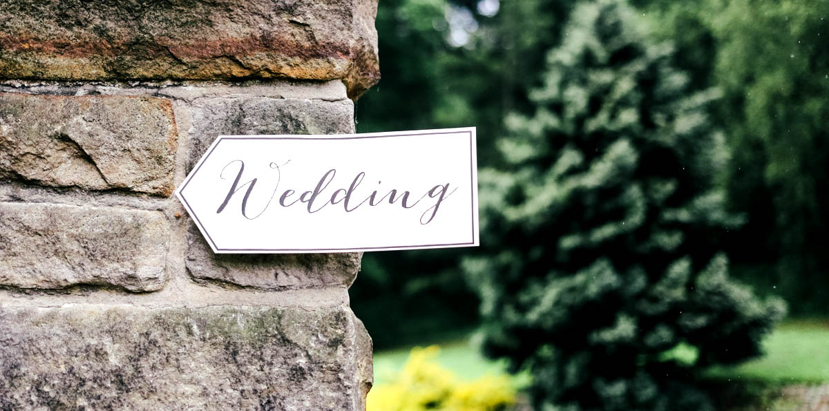 Image of a homemade sign on a wall with the word 'wedding' written on it.